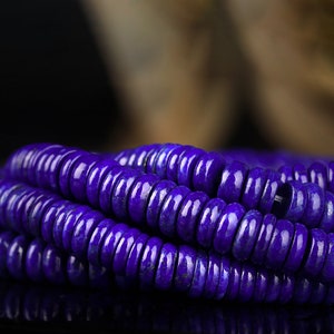 May include: A strand of deep blue lapis lazuli beads, each bead is round and slightly flattened, creating a smooth and polished look.