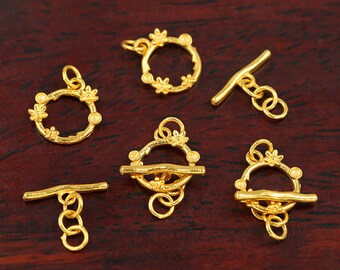 Puede incluir: Seis cierres de metal dorado con un diseño floral. Los cierres tienen forma de círculo con una barra que se desliza a través del círculo. Los cierres son perfectos para agregar un toque de elegancia a las joyas.