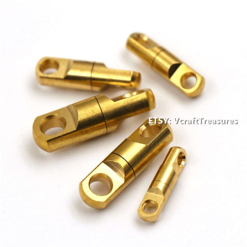 May include: Five gold-colored swivel snap hooks of varying sizes. The hooks are made of metal and have a smooth, polished finish.