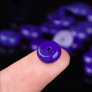 May include: A deep blue lapis lazuli bead with a small hole in the center. The bead is round and has a smooth, polished surface.