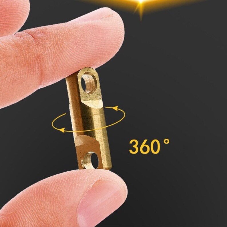 May include: A gold-colored swiveling connector with a 360-degree rotation. The connector is held between two fingers.