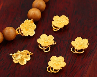 Puede incluir: Seis cierres de color dorado en forma de flor con una superficie texturizada. Los cierres están diseñados para ser utilizados como elemento decorativo para joyas u otras artesanías.