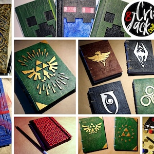 Puede incluir: Una colecci&oacute;n de diarios hechos a mano con varios dise&ntilde;os, incluyendo un diario verde con un s&iacute;mbolo Triforce dorado, un diario marr&oacute;n con un s&iacute;mbolo de f&eacute;nix y un diario verde con un s&iacute;mbolo de &aacute;rbol. Los diarios est&aacute;n todos encuadernados en cuero y tienen un aspecto vintage.