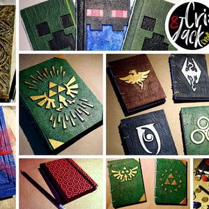 Op de afbeelding: Een verzameling handgemaakte tijdschriften en notitieboekjes met verschillende ontwerpen. De covers hebben reli&euml;fpatronen, logo's met gamethema's en geometrische vormen in groen, bruin en blauw. Sommige zijn vastgebonden met een rood lint.