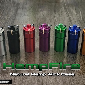 May include: A collection of seven cylindrical HempFire Natural Hemp Wick Cases in various colors, including silver, black, red, purple, green, blue, and gold. Each case has a matching colored top with a keyring and a natural hemp wick. The text "HempFire Natural Hemp Wick Case" is displayed.