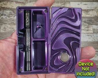 Peut inclure: Boîte de rangement violette avec fermeture magnétique. La boîte comprend un compartiment pour un vaporisateur Dynavap, qui n'est pas inclus. La boîte présente un design texturé et tourbillonnant.