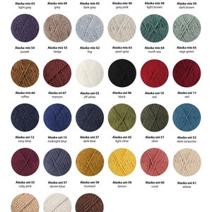 May include: A chart of 21 different colors of yarn, labeled with the names "Alaska mix" and "Alaska uni" followed by a number. The yarn is arranged in rows of six, with the last row having only five colors.