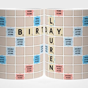 May include: A white ceramic mug with a Scrabble-style design. The mug has the words "BIRTHDAY LAUREN" spelled out using Scrabble tiles. The design incorporates game board squares and scoring information.