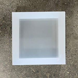 May include: A white picture frame with a white mat. The frame is rectangular and has a simple design.