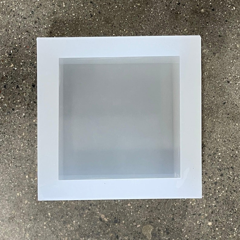 May include: A white picture frame with a white mat. The frame is rectangular and has a simple design.