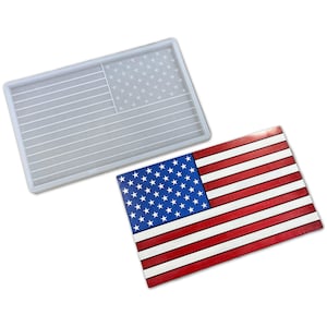 May include: A white silicone mold shaped like the American flag. The mold is shown next to a finished resin casting of the American flag.