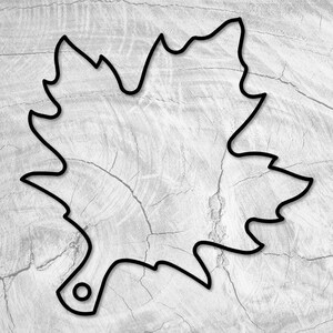 May include: A black outline of a maple leaf with a small hole in the bottom. The leaf is on a light grey background.