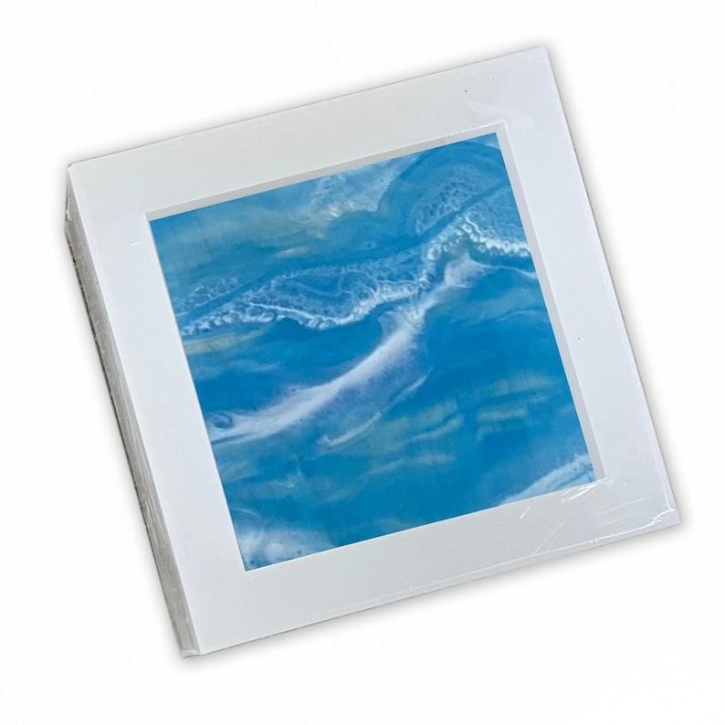 May include: A framed abstract painting with blue, white, and yellow colors. The painting depicts a swirling, wave-like pattern.