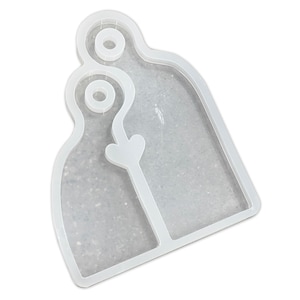 May include: White silicone mold for resin casting, shaped like two figures holding hands with a heart in the middle. The mold has two circular openings at the top.