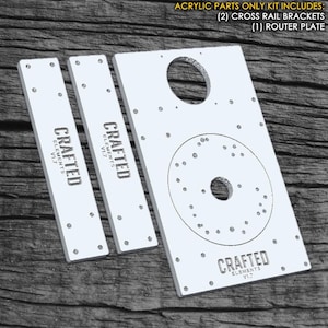 May include: White acrylic router plate with a large circle cutout and smaller circle in the centre. Two white acrylic cross rail brackets with the text "CRAFTED ELEMENTS V1.7" printed on each.  The text "ACRYLIC PARTS ONLY KIT INCLUDES: (2) CROSS RAIL BRACKETS (1) ROUTER PLATE" is printed at the top of the image.