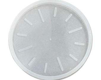 May include: White round silicone mold for making a clock face. The mold has 12 raised lines for the clock numbers.