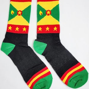 May include: A pair of black socks with red, yellow, and green stripes. The socks feature the flag of Grenada with the words "Grenada" printed on the top.