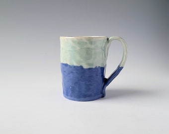 Mug with Celadon glaze over blue and white colored porcelain