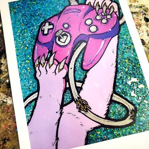 May include: A pink and purple video game controller with a paw print design. The controller is held by a pair of light purple paws with sharp claws. The background is a glittery teal color.