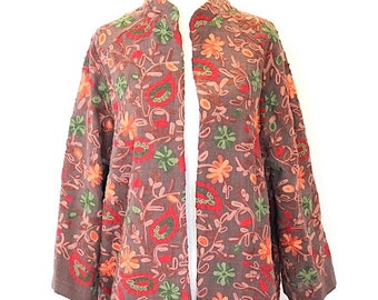 May include: A long, brown cardigan with a floral pattern in shades of red, orange, green, and pink. The cardigan has a mandarin collar and a front opening.