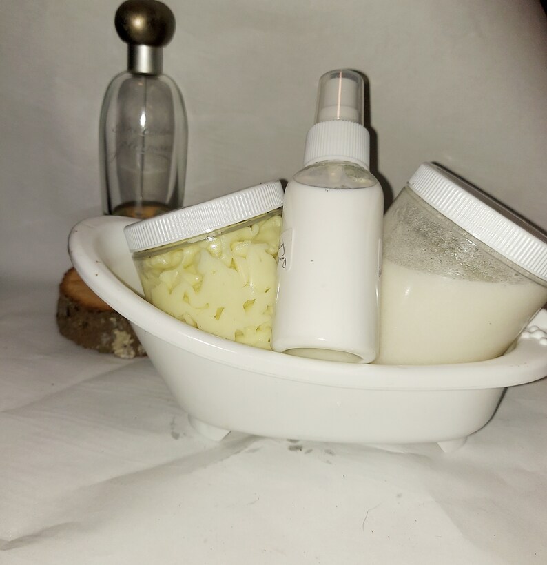 Puede incluir: Tres recipientes blancos con tapas, uno con una boquilla de pulverizaci&oacute;n, en un plato blanco con forma de ba&ntilde;era. El recipiente de la izquierda contiene una sustancia amarilla, el recipiente del centro es una botella de pulverizaci&oacute;n y el recipiente de la derecha contiene una sustancia blanca.