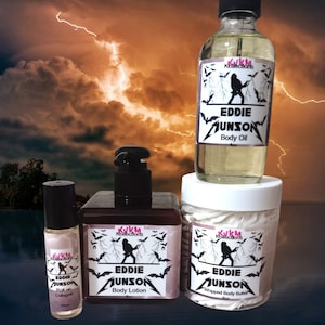 May include: A collection of body care products, including body oil, body lotion, roll-on cologne, and whipped body butter. Each product features a label with the text "Eddie Munson" and a silhouette design with bats. The background shows a stormy sky.