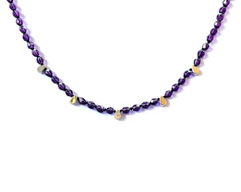 Collar de cristal de color morado oscuro con detalles en forma de lágrima de plata.