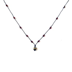 Tiny bronze heart charm necklace with red crystal accents on black silk cord