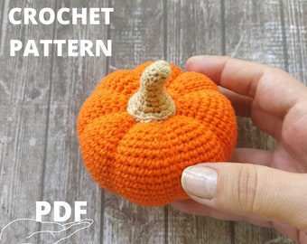 May include: Crochet pattern for a pumpkin. The pumpkin is orange and has a brown stem. The pattern is available as a PDF download.