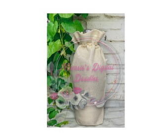 May include: A natural beige burlap wine bottle bag with a drawstring closure. The bag is hanging from a vine with green leaves and pink flowers.