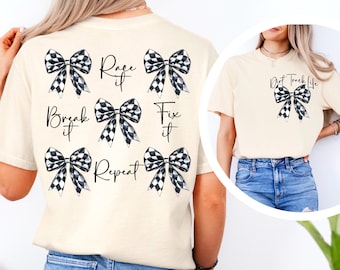 May include: A beige t-shirt with black and white checkered bows and the text "Race it, Break it, Fix it, Repeat" printed on the back. A second beige t-shirt with a black and white checkered bow and the text "Dirt Track Life" printed on the front.
