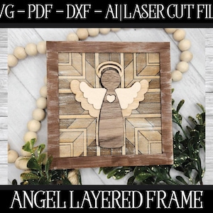 Puede incluir: Un marco de madera en capas con forma de ángel con un patrón geométrico. El ángel tiene un corazón en el pecho y alas. El marco es marrón con un acabado de madera clara.