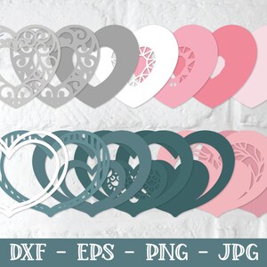 Pu&ograve; includere: Un set di 12 sagome di carta a forma di cuore sovrapposte in diverse tonalit&agrave; di rosa, grigio e verde acqua. Le sagome presentano disegni intricati, tra cui volute, linee e motivi geometrici.