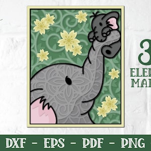 May include: A 3D layered papercraft mandala design of an elephant with a smaller elephant on its trunk. The elephant is grey with a pink ear and is surrounded by green leaves and yellow flowers. The text "3D Elephant Mandala" is in green letters.