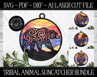 May include: A bundle of laser cut files for tribal animal suncatchers. The main design features a bear silhouette with intricate patterns set against a sunset background. Additional designs include a raccoon, fox, and owl. The text "SVG-PDF-DXF-AI | LASER CUT FILE" is at the top.