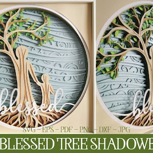 Puede incluir: Una caja de sombra 3D con un árbol de madera, dos figuras y la palabra "bendecido" tallada en la madera. El fondo es azul claro con un patrón ondulado.