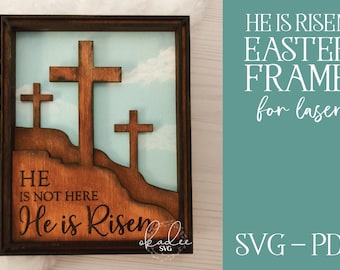 May include: A wooden laser cut Easter frame with the text "HE IS NOT HERE He is Risen" and three crosses on a blue sky background.