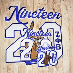 May include: A collection of embroidered patches featuring the word Nineteen in blue script, the number 2020 in white with blue borders, and the Greek letters ZΦB. The design includes illustrations of hands making a specific hand sign gesture.
