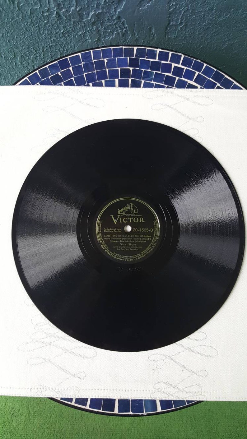 May include: Black vinyl record with a gold label featuring the Victor logo and the text "Something to Remember You By" by  Gordon Jenkins from the musical production "There's a  Clown" (Howard Dietz-Arthur Schwartz) with Gordon Jenkins and his Orchestra with  Gordon Jenkins. The record number is 20-1525-B.