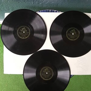May include: Three black vinyl records with gold labels. Each label has the word "Victor" and the text "Side 2", "Side 4", and "Side 5" respectively.
