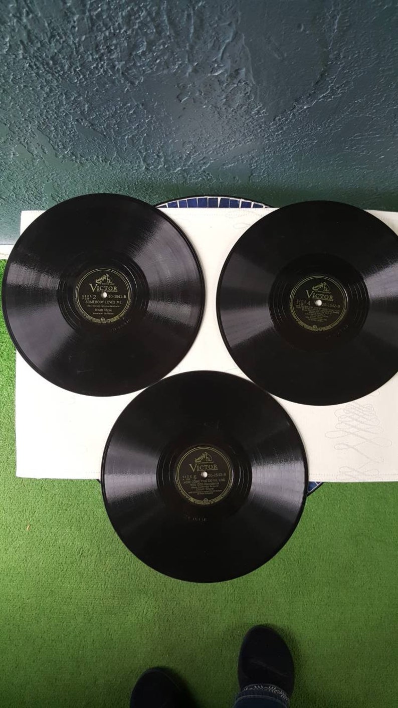 May include: Three black vinyl records with gold labels. Each label has the word "Victor" and the text "Side 2", "Side 4", and "Side 5" respectively.