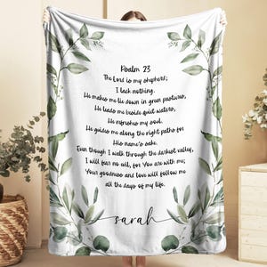 May include: White blanket with green leaf and floral design. The blanket features the text of Psalm 23, with the name "sarah" at the bottom. The blanket is a soft, cozy home decor item.