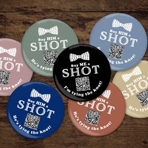 May include: Seven round buttons with a white bow tie design and the text "Buy HIM a SHOT" or "Buy ME a SHOT" and a QR code. The text below the QR code says "He's tying the knot!" or "I'm tying the knot!" The buttons are in various colours including pink, blue, green, black, and brown.