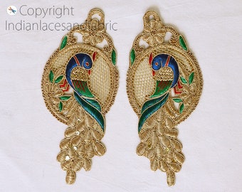 May include: Two gold embroidered peacock appliques with blue, green, and red accents. The peacocks are surrounded by a circular design with floral details.