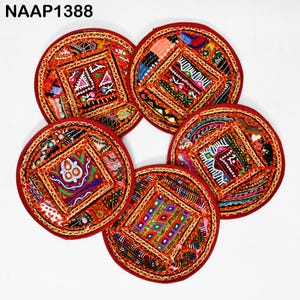 Può includere: Set di cinque sottobicchieri rotondi, colorati e ricamati con un bordo rosso. Ogni sottobicchiere presenta un design quadrato con motivi e decorazioni intricate.