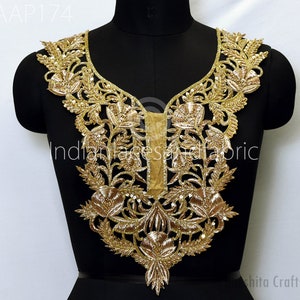 Può includere: Bordatura per scollatura ricamata in oro con un motivo floreale. La bordatura è su uno sfondo nero e presenta un motivo delicato e intricato.