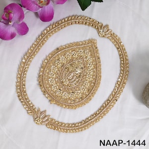 Pode incluir: Um conjunto de aplicações bordadas em dourado, composto por uma borda grande de formato oval e uma peça central em forma de gota. Ambos os elementos são decorados com fio metálico dourado, lantejoulas e pequenas contas brancas. O texto NAAP-1444 é visível.