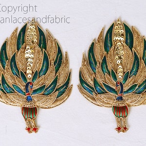 May include: Two gold peacock embroidery patches with green and blue feathers and red and green details. The peacocks are facing opposite directions.