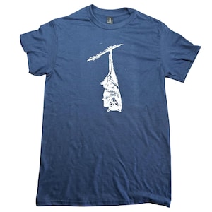 May include: A navy blue short-sleeved t-shirt featuring a white graphic print of a bat hanging upside down from a branch. The design is centred on the chest of the shirt, which has a crew neckline and a standard fit, showcasing a simple cotton-like texture.