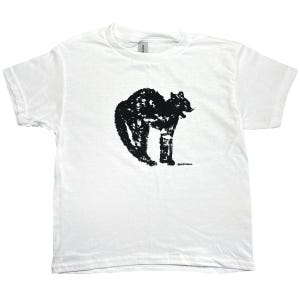 May include: White t-shirt with a black, distressed illustration of a cat. The cat is depicted with an arched back and textured fur. The design is centrally placed on the shirt, which has short sleeves and a crew neck.